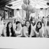 Przyjaciółki przy stole na wieczorze panieńskim z balonami